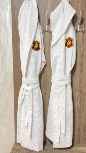 two white aprons with crowns hanging on a wall at Four Seasons In Carpathians in Migovo