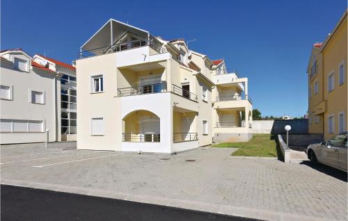 een groot wit gebouw met een parkeerplaats bij Amazing Apartment In Vodice With Wifi in Vodice