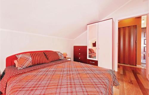 a bedroom with a bed with a red comforter at Amazing Apartment In Vodice With 1 Bedrooms And Wifi in Vodice