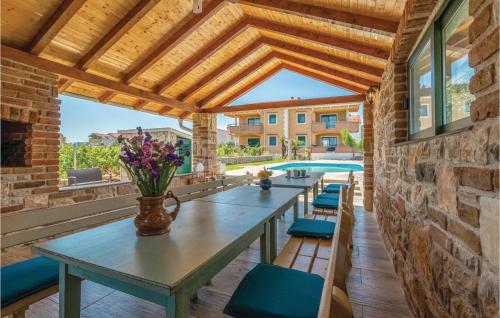 un patio con mesa, sillas y piscina en Awesome Home In Pasman With House Sea View en Pašman