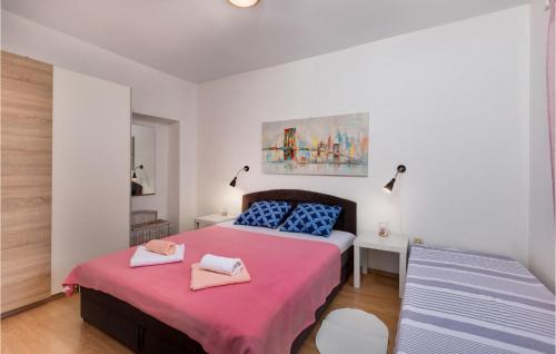 a bedroom with two beds with pink and blue pillows at Amazing Apartment In Gabonjin With Kitchen in Gabonjin