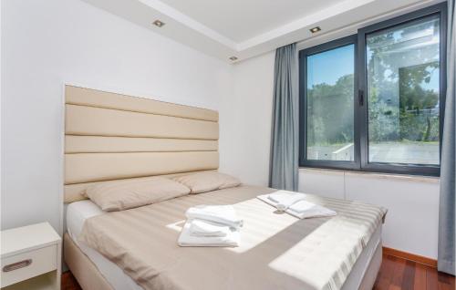 a bedroom with a large bed with a window at Lovely Apartment In Malinska With Wifi in Malinska