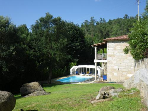 uma piscina em um quintal ao lado de uma casa em Hotel Rural Quinta de Novais em Arouca