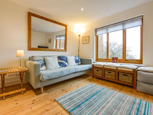 a living room with a couch and a mirror at Chough Cottage in Cawsand