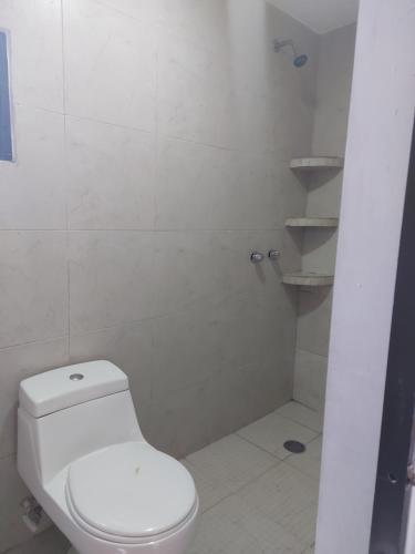 a white bathroom with a toilet and a shower at EL ANCLA in Ciudad del Carmen