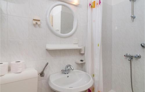 a white bathroom with a sink and a mirror at Stunning Apartment In Supetar With 2 Bedrooms And Wifi in Supetar
