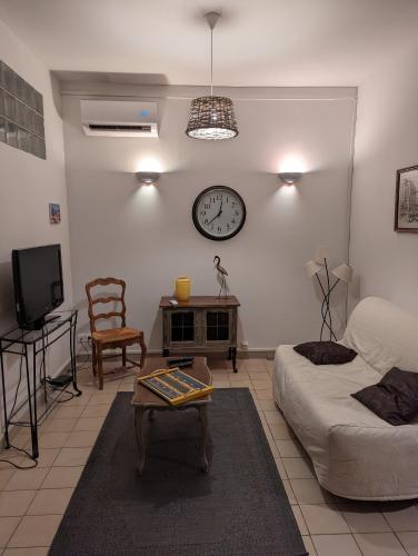 a living room with a bed and a clock on the wall at le Cocooning Marseillais in Marseille