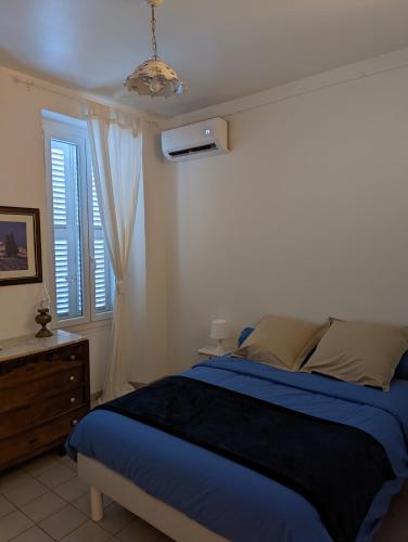 a bedroom with a blue bed and a window at le Cocooning Marseillais in Marseille