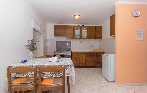kuchnia ze stołem i krzesłami oraz kuchnia z kuchenką w obiekcie Apartment Selo Rakalj Op-1875 w mieście Rakalj
