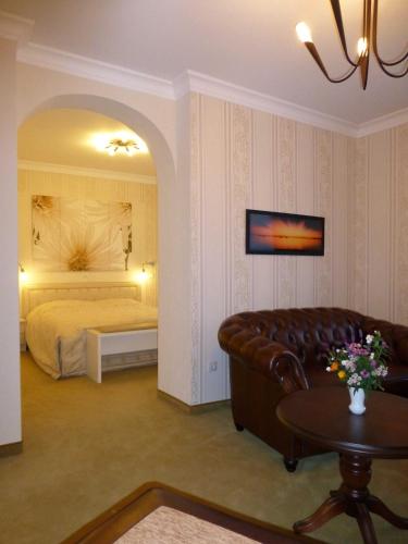 a living room with a couch and a bed at Hotel Villa Luise in Bad Rothenfelde