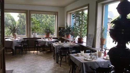CremlingenにあるHotel Zum Weinbergの白いテーブルと椅子、窓のあるレストラン
