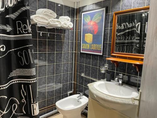La salle de bains est pourvue d'un lavabo, de toilettes et d'un miroir. dans l'établissement le Cocooning Marseillais, à Marseille
