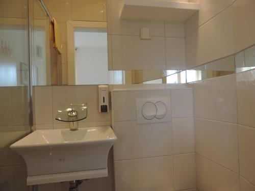 Baño blanco con lavabo y espejo en Guesthouse Nikola, en Lagos de Plitvice