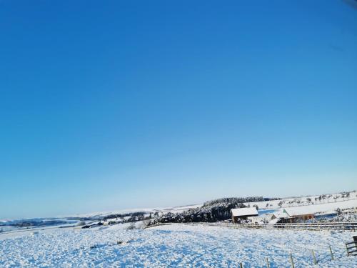 a snow covered field with a town in the background at The Manor House Inn in Shotley Bridge
