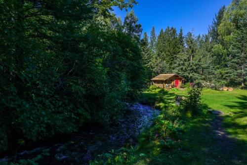 a small red barn in the middle of a field at Hope Alaska's Bear Creek Lodge in Hope