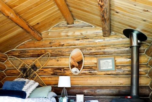 a bedroom with a wooden ceiling with a fan at Hope Alaska's Bear Creek Lodge in Hope