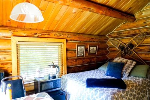a bedroom with a bed in a log cabin at Hope Alaska's Bear Creek Lodge in Hope