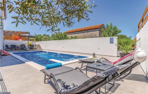 uma piscina com cadeiras e uma mesa e uma piscina em Gorgeous Apartment In Pula With Kitchen em Muntić