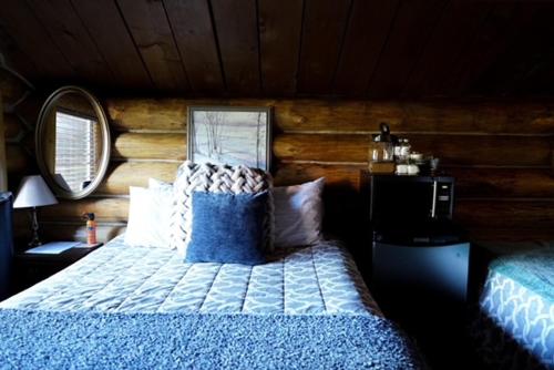 a bedroom with a bed and a wooden wall at Hope Alaska's Bear Creek Lodge in Hope