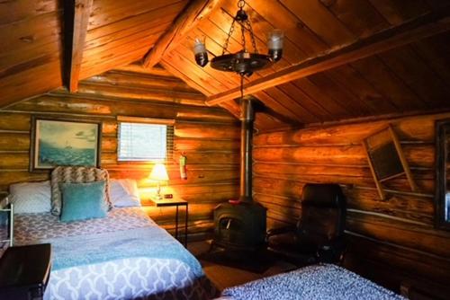 a bedroom with a bed in a log cabin at Hope Alaska's Bear Creek Lodge in Hope