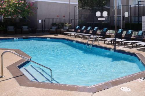 a large swimming pool with chairs in a hotel at Sonesta ES Suites Dallas Medical Market Center in Dallas