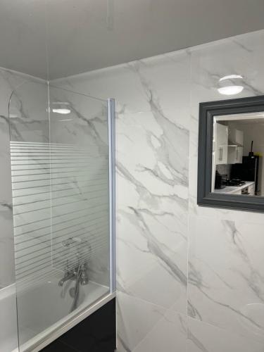 a bathroom with a shower with a sink and a mirror at 4 BR, Large & Modern Private House Central Location in Newcastle upon Tyne
