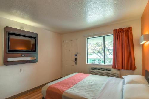 a bedroom with a bed with a tv and a window at Motel 6-Arcadia, CA - Los Angeles - Pasadena Area in Arcadia