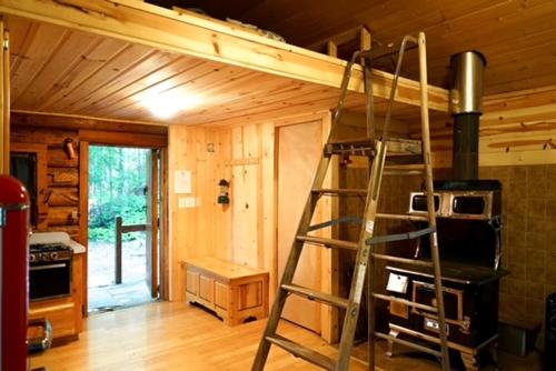 a ladder in a room with a stove at Hope Alaska's Bear Creek Lodge in Hope