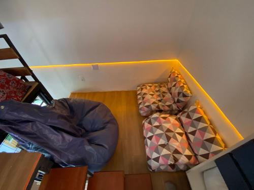 an attic room with two chairs and a bed at Minicasa Brasileira in Sorocaba