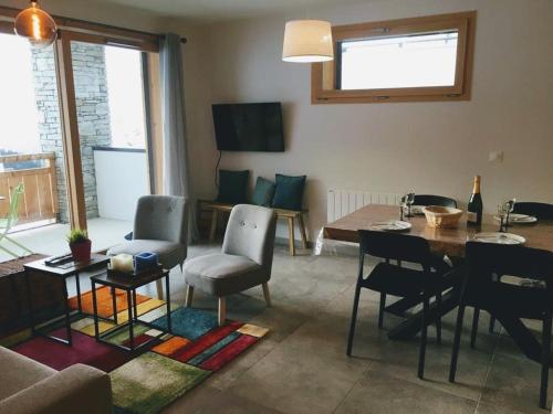 a living room with a table and chairs and a couch at Superbe appartement de 62 m2 au pied des pistes in Oz