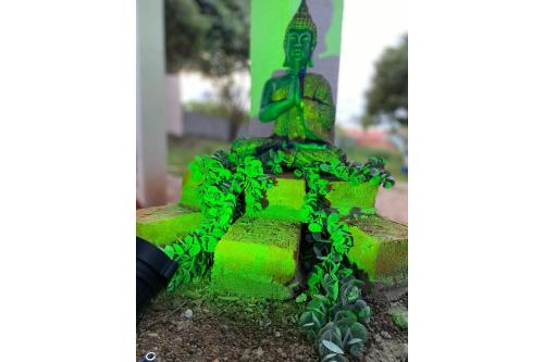 a green statue sitting on top of a cement block at Minicasa Brasileira in Sorocaba