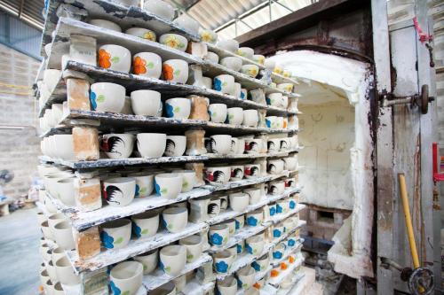 a wall filled with lots of cups on display at Lampang River Lodge in Lampang