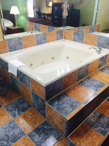 a large bath tub in a room with tiles at Travelers Inn in Rosenberg