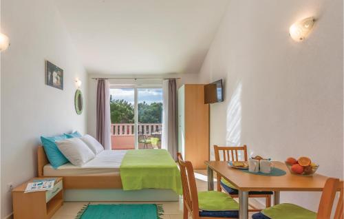 Cette petite chambre comprend un lit, une table et une fenêtre. dans l'établissement Cozy Apartment In Baska Voda With Kitchen, à Baška Voda