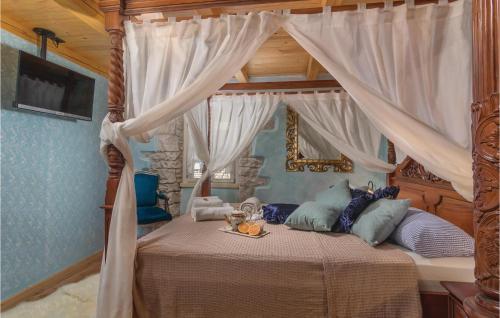 a bedroom with a canopy bed with a tray of food on it at Awesome Home In Hrboki With Outdoor Swimming Pool in Hrboki