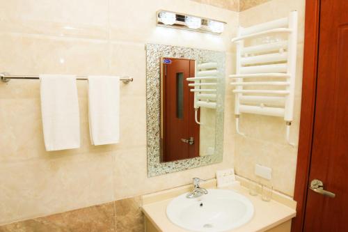 a bathroom with a sink and a mirror and towels at Guide Hotel in Ulaanbaatar