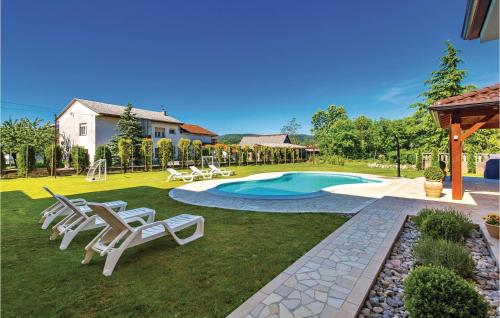 a yard with chairs and a swimming pool at Gorgeous Home In Drazice With Outdoor Swimming Pool in Dražice