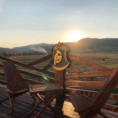 a fence with a bench with a sign on it at Four Seasons In Carpathians in Migovo