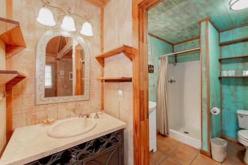 a bathroom with a sink and a mirror and a toilet at Seven Bluff Cabins in Concan