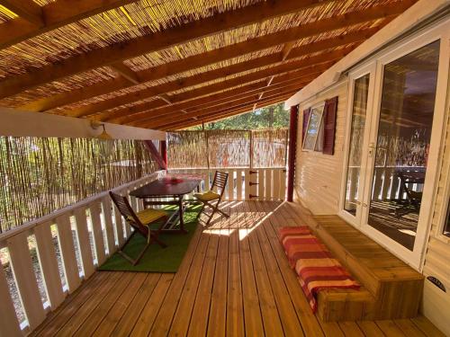 une terrasse en bois avec une table et des chaises dessus dans l'établissement Mobil home au Camping Sellig, au Muy