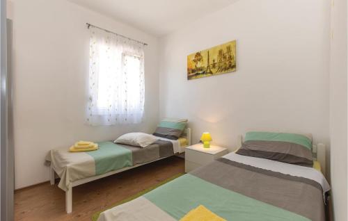 - 2 lits jumeaux dans une chambre avec fenêtre dans l'établissement Amazing Home In Kostrena With Kitchen, à Kostrena