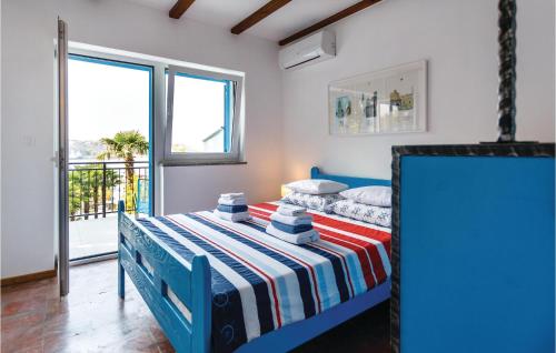a bedroom with a blue bed with a striped blanket at 4 Bedroom Beautiful Home In Omisalj in Omišalj
