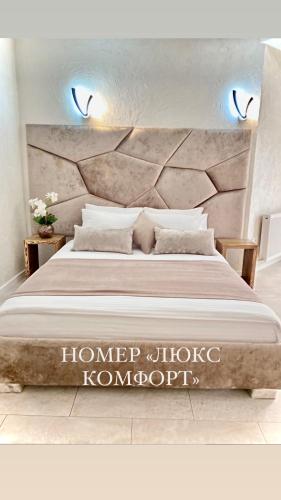 a bedroom with a large bed with a large headboard at Four Seasons In Carpathians in Migovo