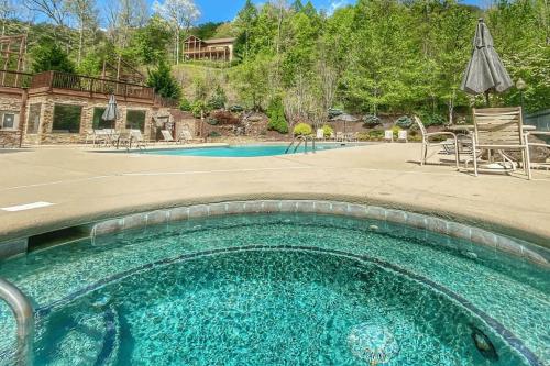 a swimming pool in a yard with chairs and an umbrella at Condo with Stunning Mountain and 6th Green views near Harrahs Cherokee Bryson City in Whittier