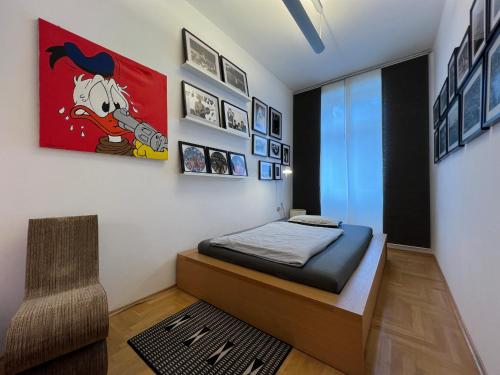 1 dormitorio con 1 cama y una pintura en la pared en Vienna Design Apartment by Rabe - kostenfreier Parkplatz & Netflix & Coffee-Bar - nahe Schloss Schönbrunn, en Viena