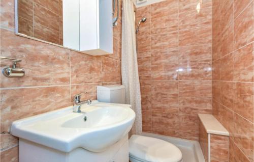 a bathroom with a sink and a toilet and a mirror at Beautiful Apartment In Omis With House Sea View in Omiš