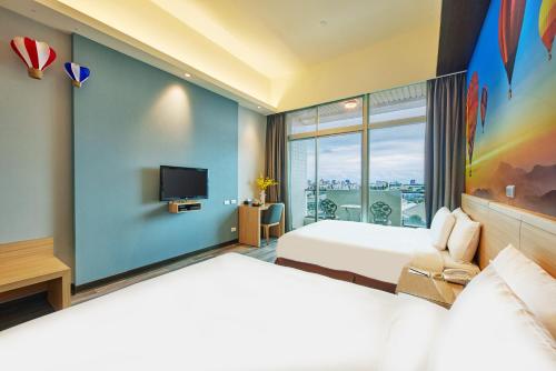 a hotel room with two beds and a tv at Naruwan Inn in Taitung City