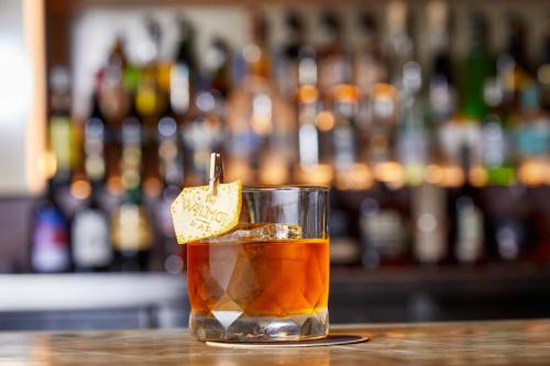 a drink sitting on a bar with a slice of lemon at Kimpton Margot Sydney by IHG in Sydney