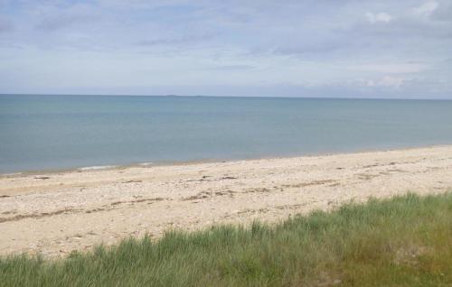 une plage de sable avec l'océan en arrière-plan dans l'établissement Nice Home In Saint-Marcouf With Kitchen, à Saint-Marcouf