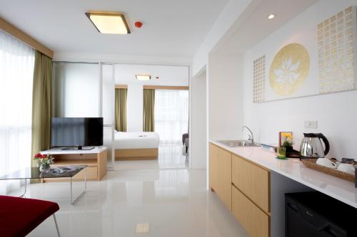 1 dormitorio con 1 cama y baño con lavabo. en Modern Thai Suites, en Phuket